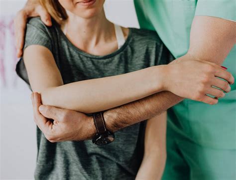 Physical therapy aide assisting a patient